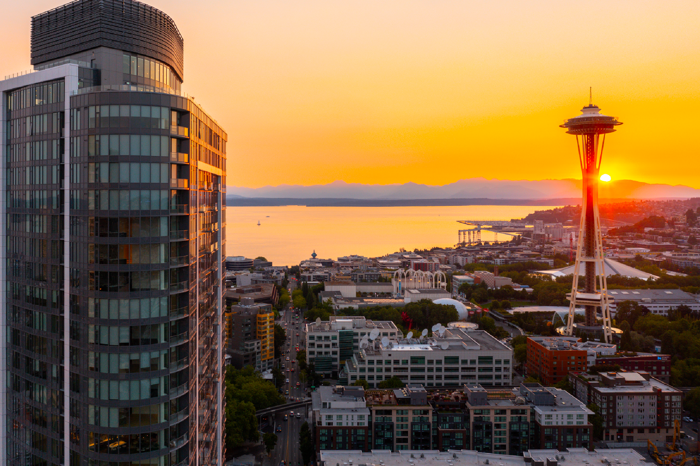 A picture of Spire, a 41 story building and the Space Needle at sunset.